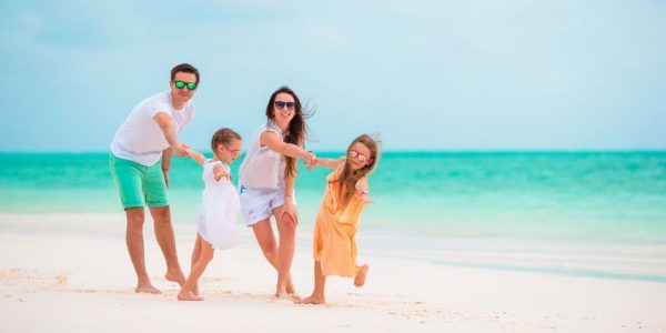 Happy beautiful family on white beach having fun