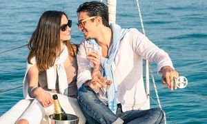 Young Couple In Love On Sail Boat With Champagne Flute Glasses –